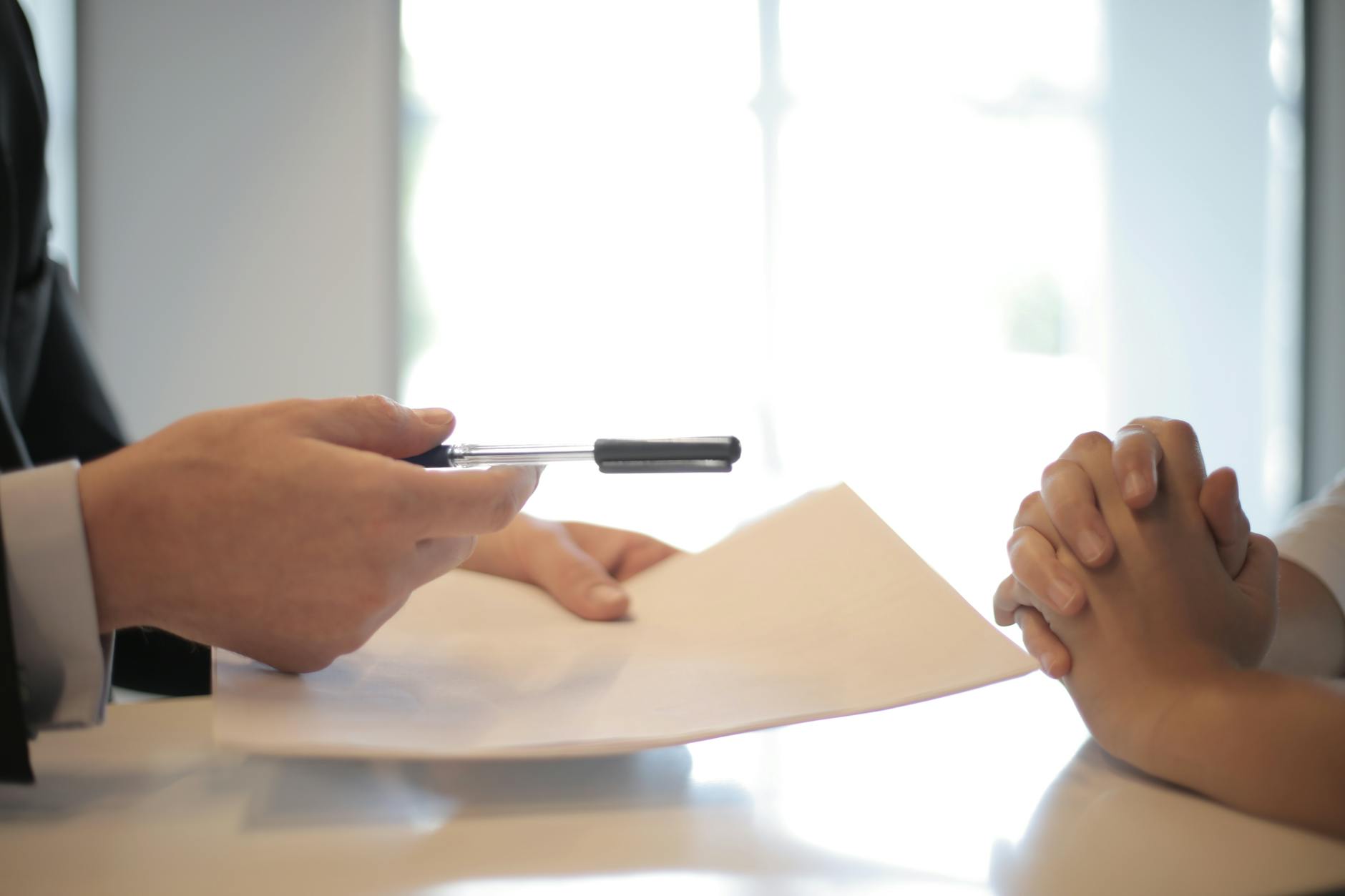 Insurance agent gives the contract to a woman to sign a Life Insurance policy and have a conversation about the costs before buying the policy