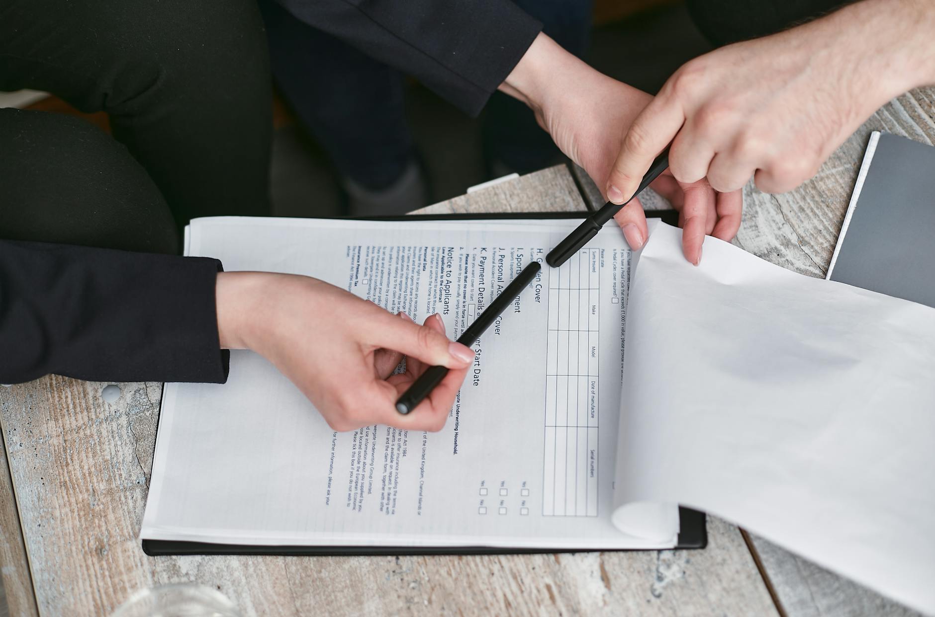 person holding black pen reviewing a document